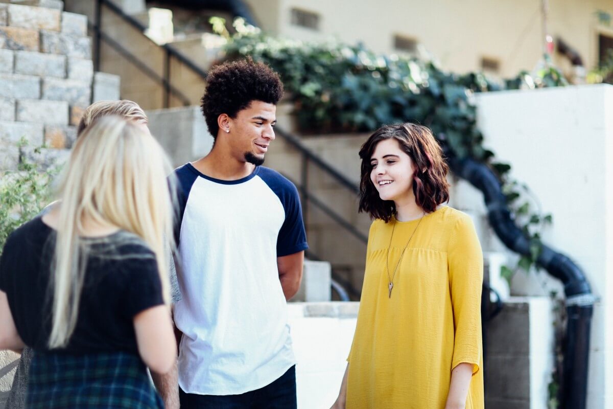 students talking outside house