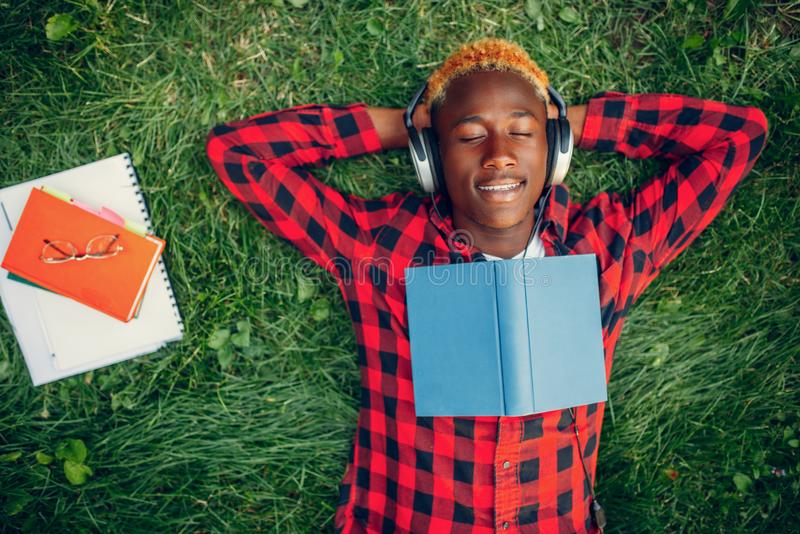 student-resting-grass-top-view-headphones-summer-park-teenager-studying-leisures-outdoors-159726831